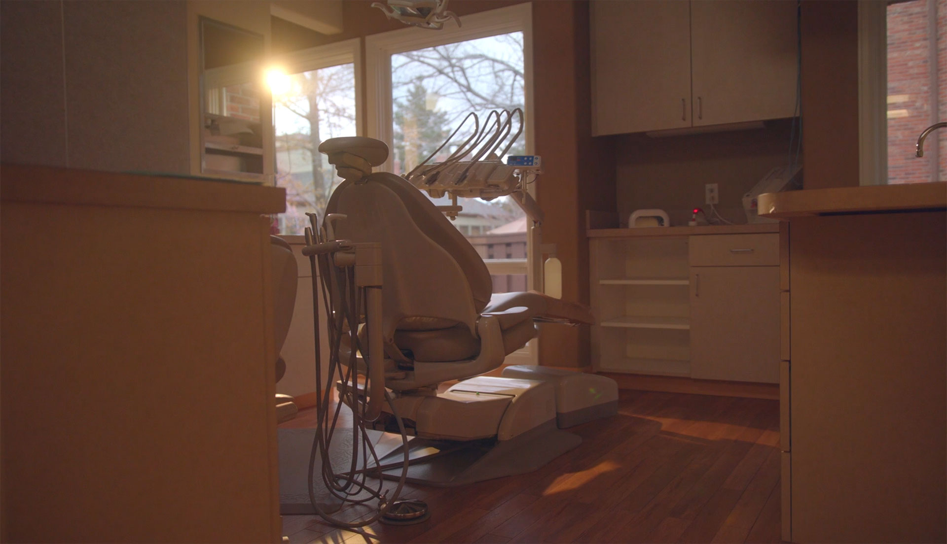 A modern dental practice with a blue and white chair, a dental treatment table, and medical equipment.